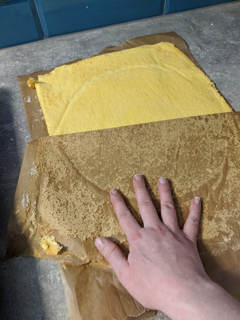 Peeling the baking paper away from the cake.