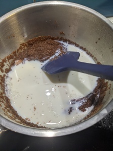 Adding milk in with the teff grain that has been cooking and has soaked up all the water. 